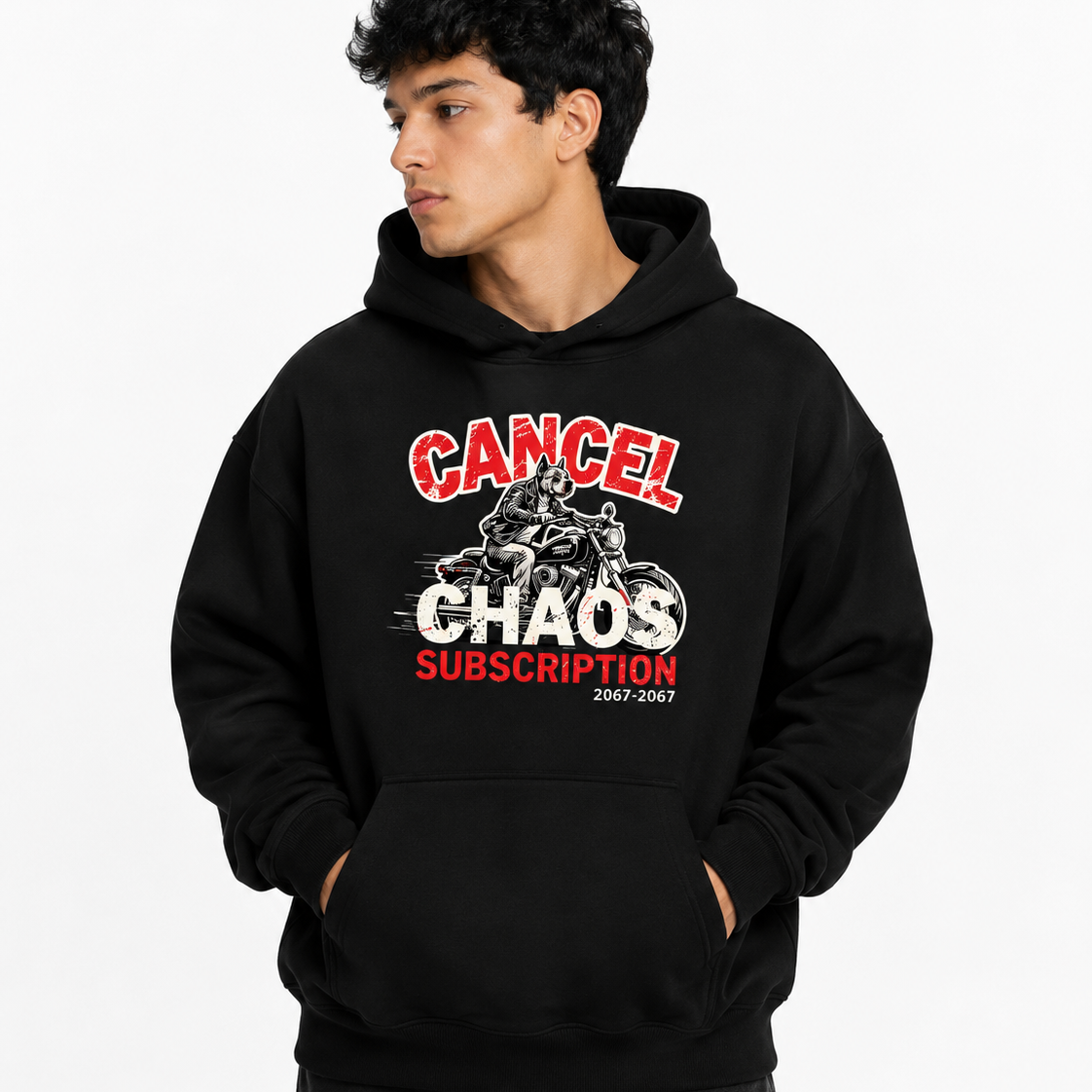 A man wearing a black pullover hoodie with a graphic print that reads 'CANCEL CHAOS SUBSCRIPTION 2047-2067' in red and white, posed against a light gray background.
