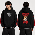 A man modeling a black hoodie from the front and back against a light gray studio background. The front has white text reading 'MARKED BY THE WILD' on the chest, and the back has red text reading 'FREEDOM REBEL Big Nap Energy' with a dog illustration.