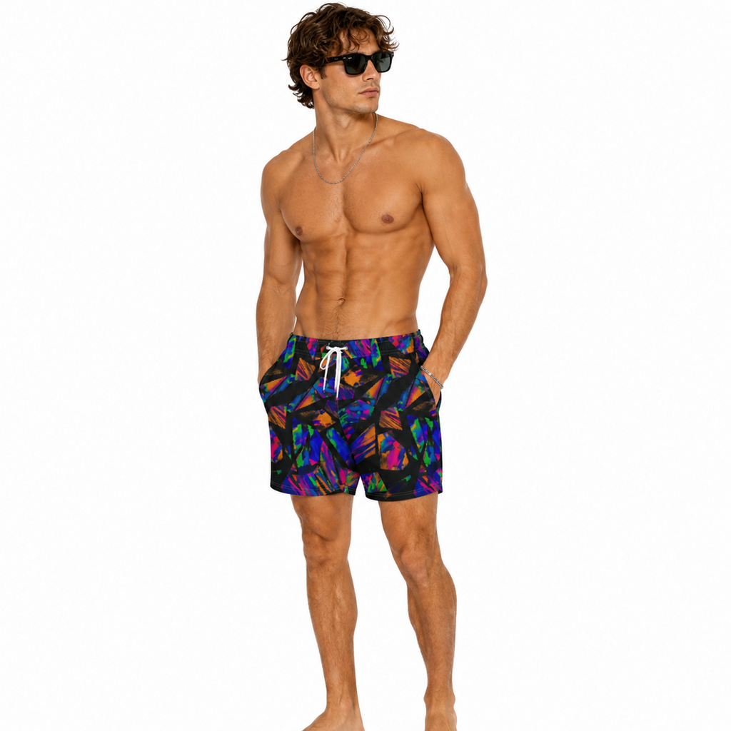 A shirtless male model wearing colorful swim trunks with a vibrant multicolor abstract pattern on a solid white background.