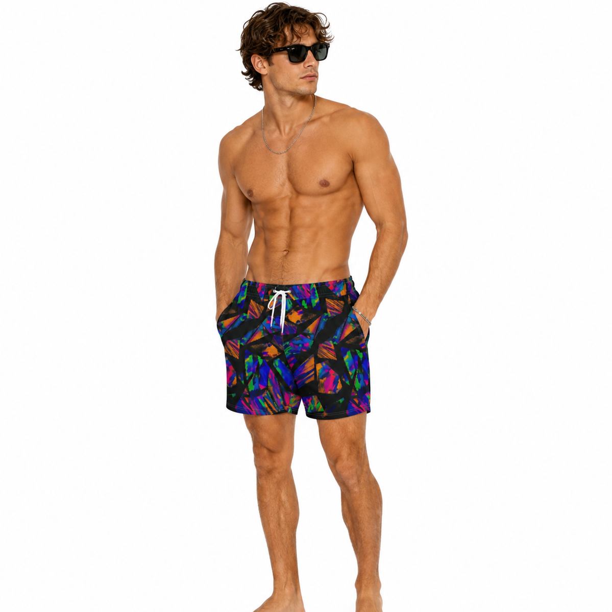 A shirtless male model wearing colorful swim trunks with a vibrant multicolor abstract pattern on a solid white background.